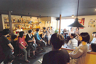 ラム酒専門のバーブルーケイン。店主(大橋さん)の後ろには200種ものラム酒が並ぶ(写真はB班の喫茶休憩中) ラム酒専門のバーブルーケイン。店主(大橋さん)の後ろには200種ものラム酒が並ぶ(写真はB班の喫茶休憩中)